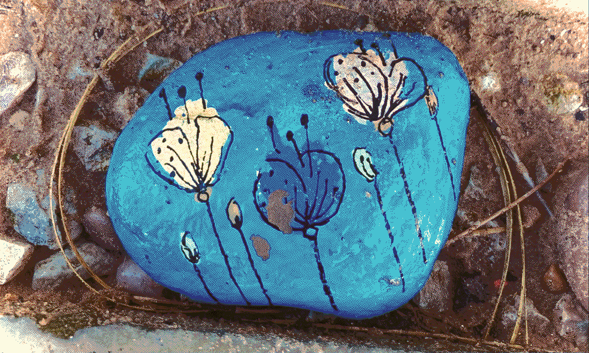 a small stone with blue flowers drawn on it